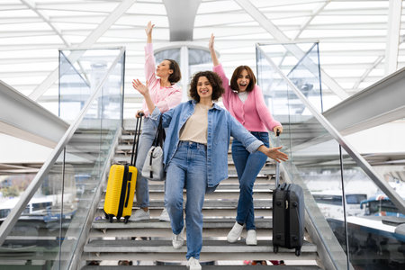 Travelling Together. Three Cheerful Women With Suitcases Having Fun At Airportの写真素材