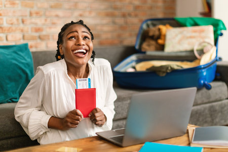 Online tickets booking and summer vacation concept. Excited african american woman using laptop to buy hot tour at webの写真素材