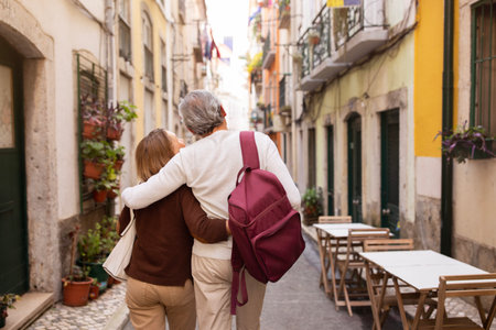 Senior Couple Hugging Walking On Lisbon Street Outdoors, Back Viewの写真素材