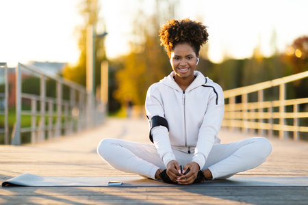 Sporty Young African American Female Practicing Yoga Outdoorsの写真素材