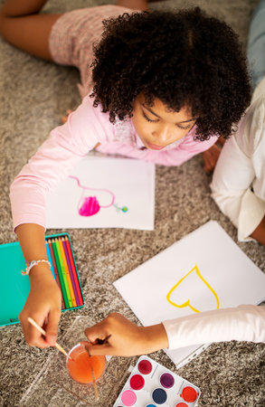 Vertical Shot Of African Girl Drawing At Home, Above Viewの写真素材
