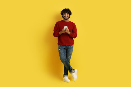 Handsome indian guy with cell phone in his handsの写真素材