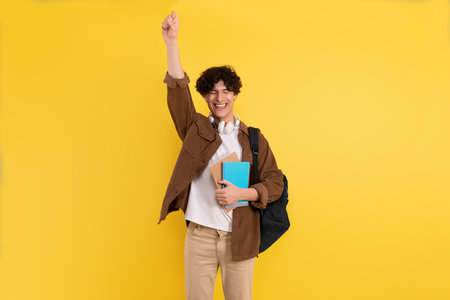 Joyful Male Student Gesturing Yes Posing On Yellow Studio Backgroundの写真素材