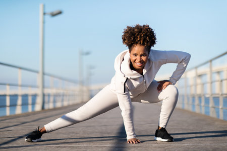 Sporty Young Black Female In Activewear Warming Up Before Jogging Outdoors