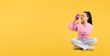 Happy young caucasian brunette female in sunglasses with camera make photo, sits on floor, looks at free spaceの写真素材