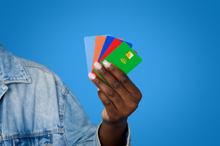 Cropped of black woman holding various colorful bank cardsの写真素材