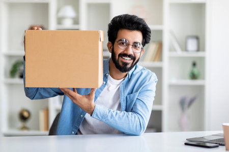 Delivery Concept. Happy Indian Man Demonstrating Big Cardboard Box At Cameraの写真素材