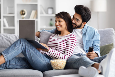 Relaxed multicultural spouses chilling on couch at homeの写真素材