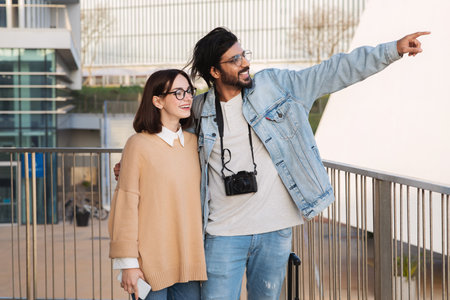 Smiling young different man and woman travelers in casual and glasses with camera enjoy tripの写真素材