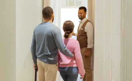 Hotel Worker Opening Door Showing Suite To Unrecognizable Tourists Indoorの写真素材