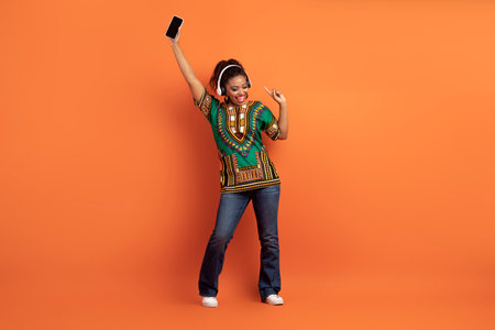 Positive cool black woman enjoying nice music app