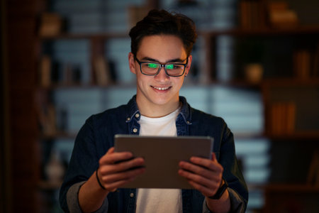 Smiling young guy holding using digital tablet pc at office