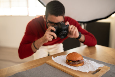 Food photographer young man taking photos of delicious hamburgerの写真素材