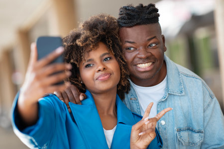 Travel Fun. Cheerful Black Couple Taking Selfie With Smartphone At Railway Stationの写真素材