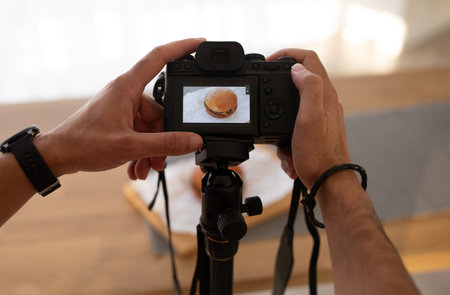 Unrecognizable man taking photo of humburger, using digital cameraの写真素材