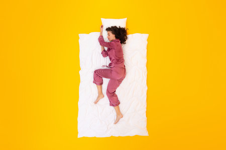 Lady Sleeping Lying On Blanket And Pillow Over Yellow Backgroundの写真素材