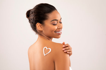 Heart shaped body lotion sign on black woman shoulderの写真素材