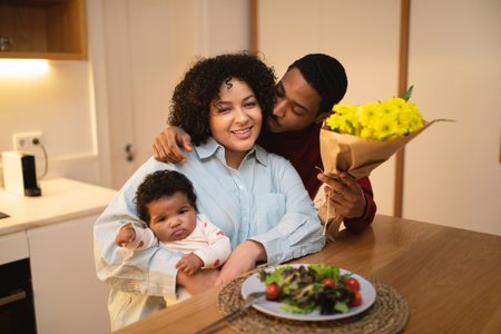 Loving black husband kissing his beautiful wife holding baby boyの写真素材