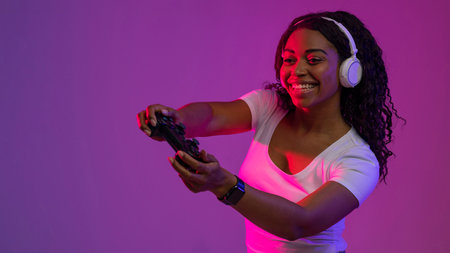 Modern Entertainment. Smiling Black Woman In Neon Light With Joystick In Handsの写真素材