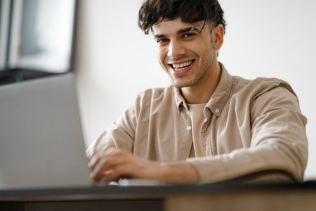 Happy Arabic Man Using Laptop Typing And Working In Officeの写真素材