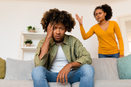 Black Couple Having Quarrel, Wife Shouting At Unhappy Husband Indoorsの写真素材