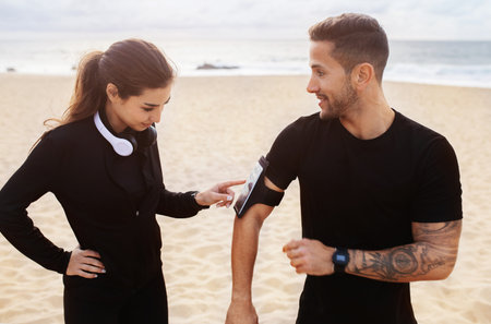 Have you got your running playlist ready. Sporty young man and woman preparing for working out...