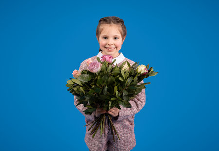 Smiling european little girl with bouquet of flowers enjoy spring birthdayの写真素材