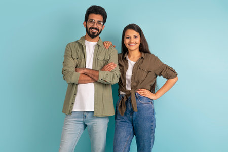Cheerful indian young couple posing together on colorful backgroundの写真素材