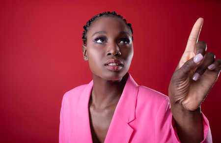 Stylish Black Woman Wearing Pink Blazer Pointing Away With Fingerの写真素材