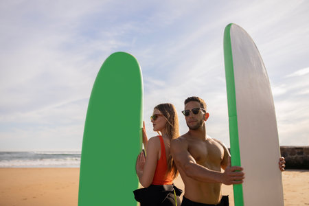 Beautiful Young Couple Posing With Surf Boards On Beach In Summerの写真素材