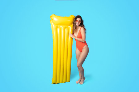 Cheerful millennial asian woman in swimsuit, sunglasses with inflatable mattress enjoy free time and...