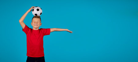 Sport Ad. Funny Preteen Boy Posing With Football Ball On Headの写真素材
