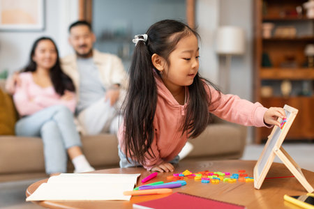 Asian Little Daughter Playing With Alphabet Board Learning At Homeの写真素材