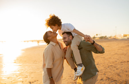 Beachside bliss. Family of three spending time by sea, walking on the beach and enjoying family bonding time outdoorsの写真素材