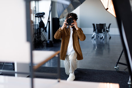 Capturing creativity. Dynamic young male photographer working in professional photostudio with modern equipmentの写真素材