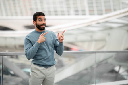 Arabic Guy Pointing Fingers Aside At Free Space At Airportの写真素材