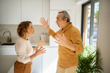 Relationship problems. Angry senior man arguing with his wife at kitchen, spouses having difficulties in marriageの写真素材
