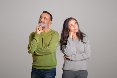 Pensive positive caucasian aged husband and wife think, looking at empty space