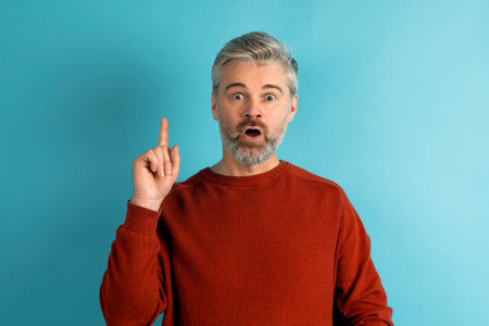 Middle aged caucasian man wearing casual clothes pointing finger upの写真素材