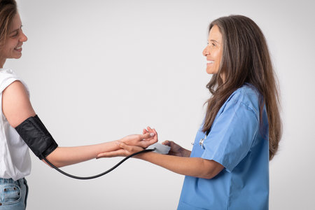 Healthcare, hospital and medicine concept. Cheerful senior doctor woman measuring blood pressure to...