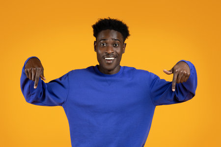 Handsome young african american man pointing downの写真素材