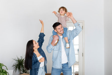 Portrait of excited young parents with little son posing in new apartmentの写真素材
