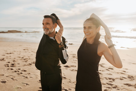 Cheerful mature european man and lady doing arm exercises, stretching and warmup, enjoy workout