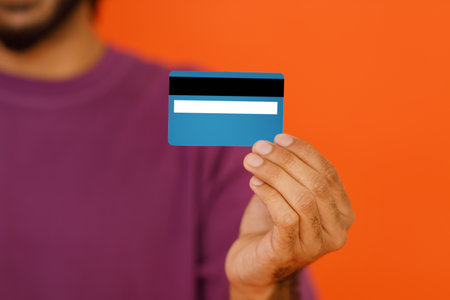 Cropped image of man holding in hand credit bank card