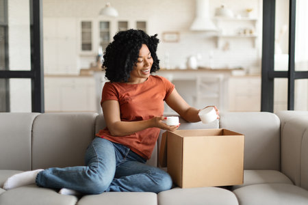 Online Shopping. Smiling black woman opening parcel box with cosmetics at home