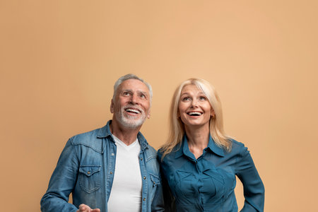 Excited senior couple looking up at copy space