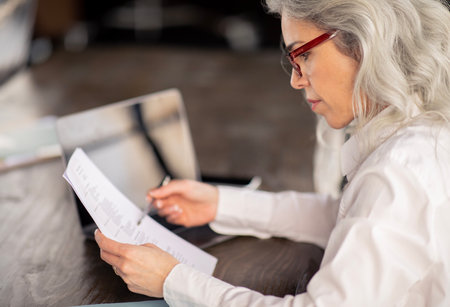 HR Manager Lady Reading Resume Sitting In Office, Side View