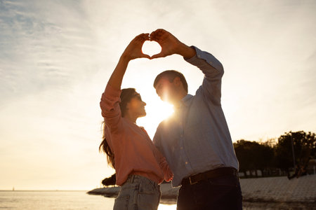 Love Story. Romantic Mature Couple Making Heart Shape With Hands On Sunsetの写真素材