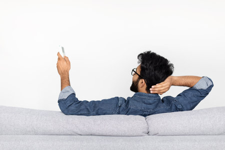 Closeup back view shot of bearded man holding remote controlの写真素材