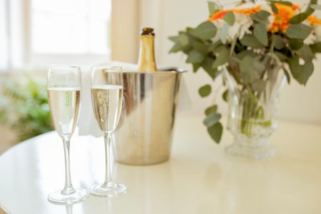 Glasses And Bottle Of Sparkling Wine Standing On Table Indoorの写真素材